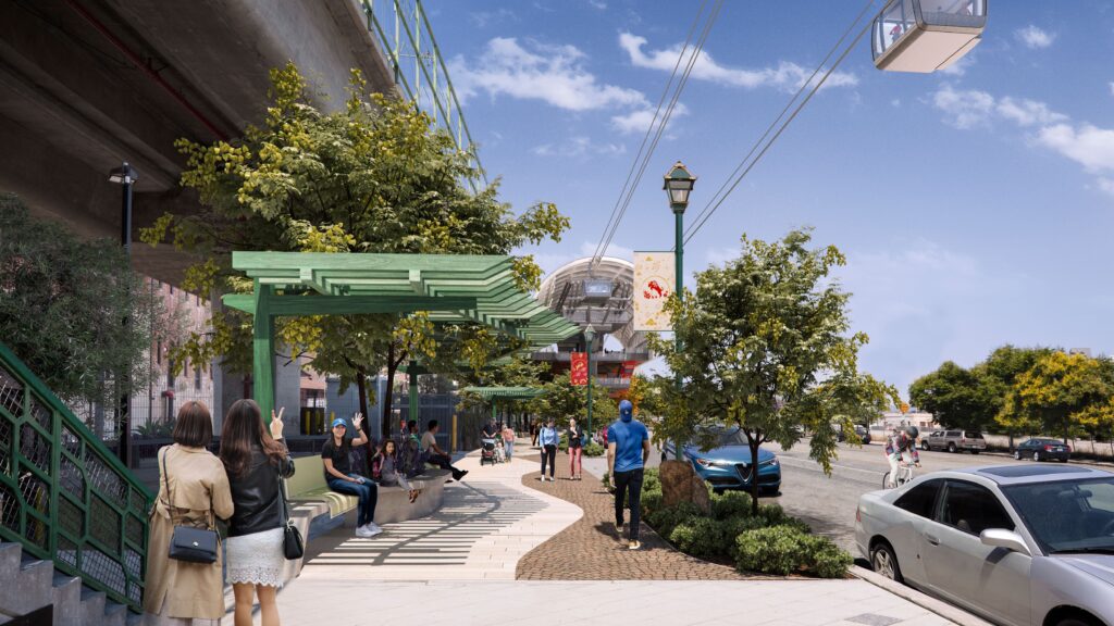 People walking along a vibrant, tree-lined urban walkway with a cable car above.
